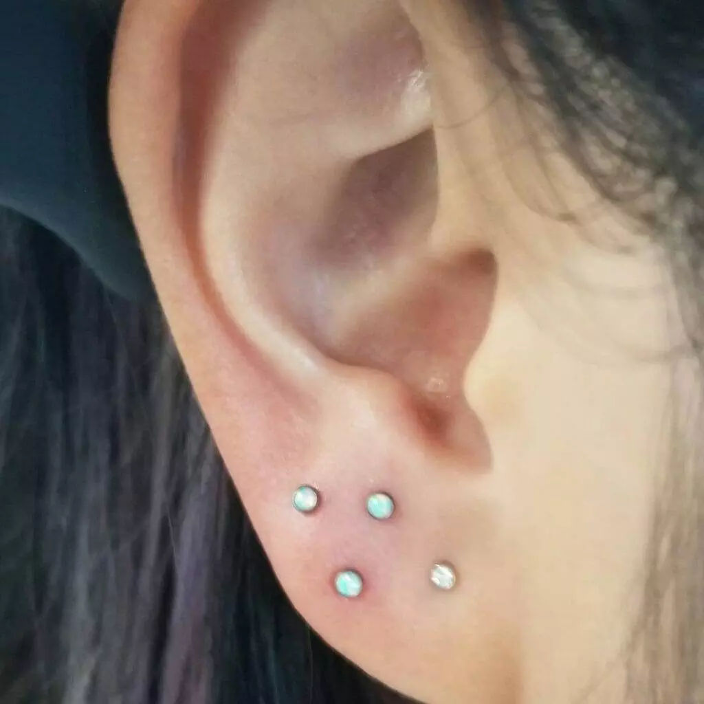 A woman's ear with three piercings styled by Nathan Atoui.