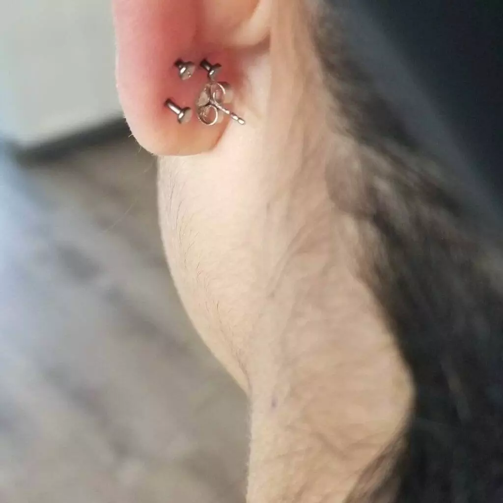 A woman's ear adorned with unique ear cuffs by Nathan Atoui.