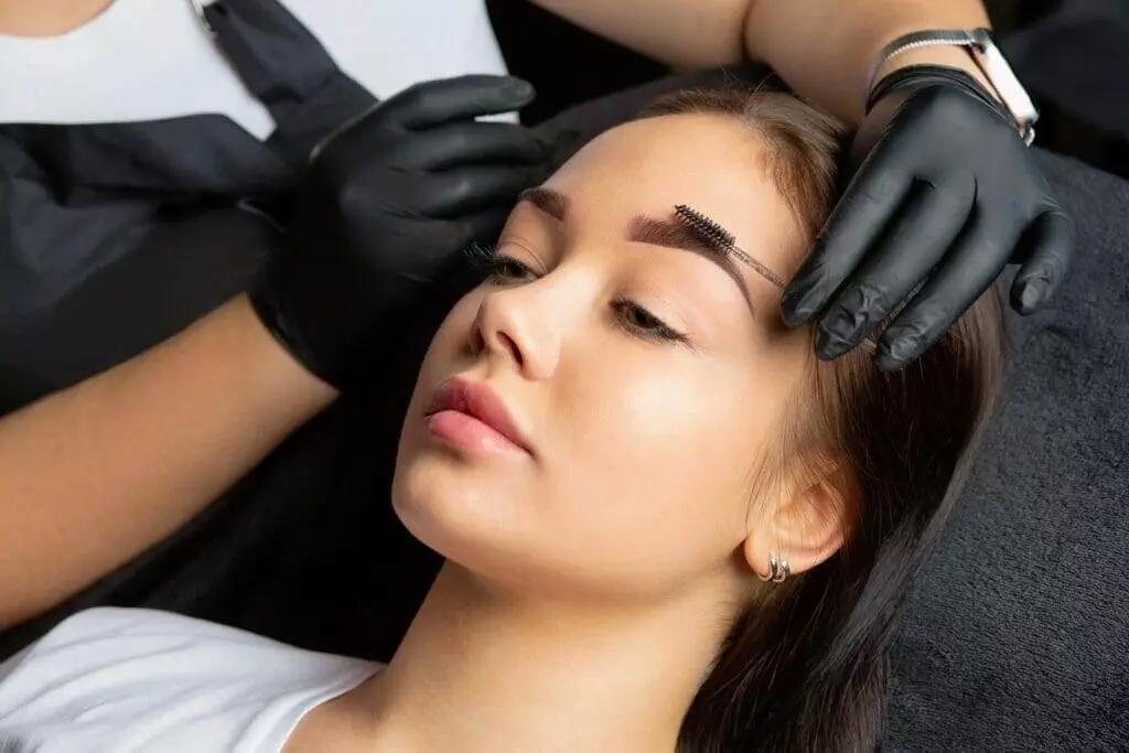 A woman enhancing her beauty with eyebrow tattooing at Embellish PB in San Diego.